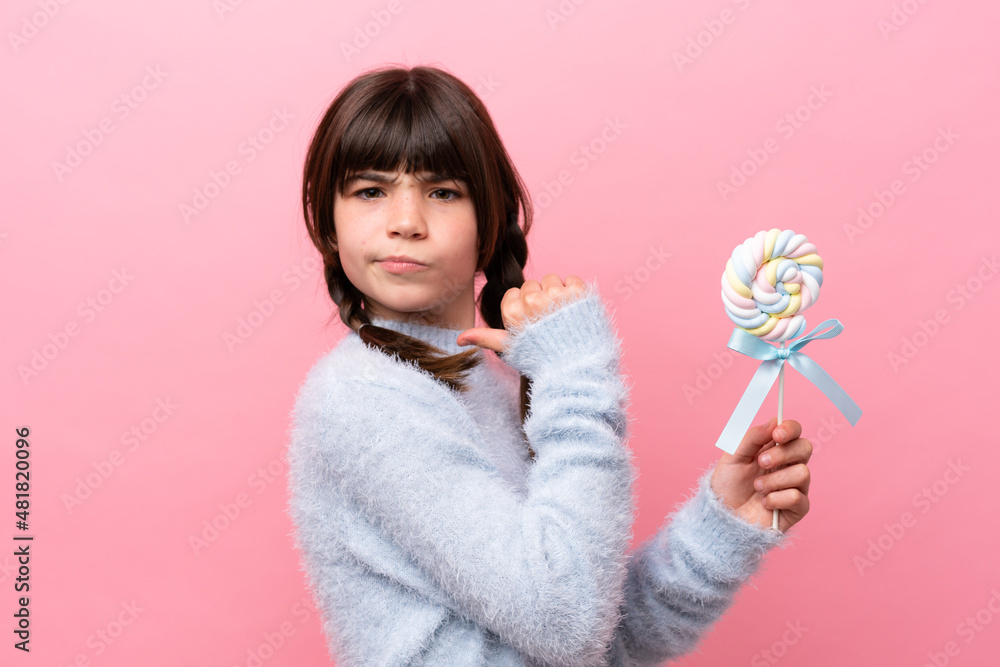 Little caucasian girl holding a lollipop proud and self-satisfied Little caucasian girl holding a lollipop proud and self-satisfied