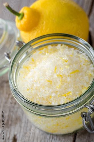 Homemade sea salt and lemon fruit scrub (bath salt, foot soak) in a glass jar close-up. Natural beauty treatment and spa recipe.