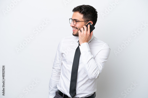 Business Brazilian man isolated on white background keeping a conversation with the mobile phone with someone © luismolinero