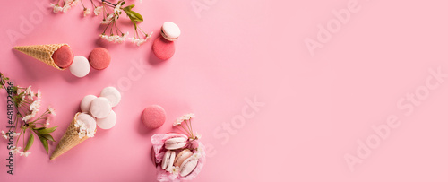 Rose sweet cookies macaroons in gift box and Cherry blossoms on pink background.