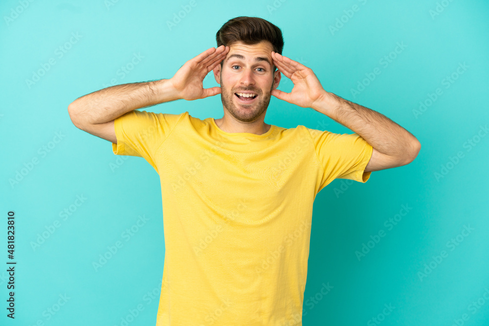 Young caucasian handsome man isolated on blue background with surprise expression Young caucasian handsome man isolated on blue background with surprise expression