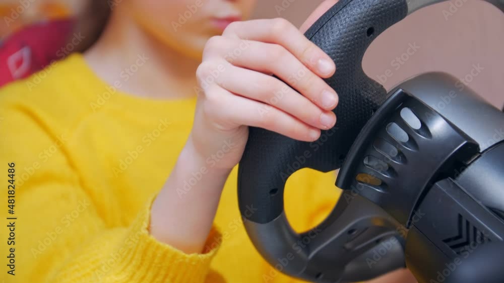 Girl driving a game wheel closeup Girl driving a game wheel closeup
