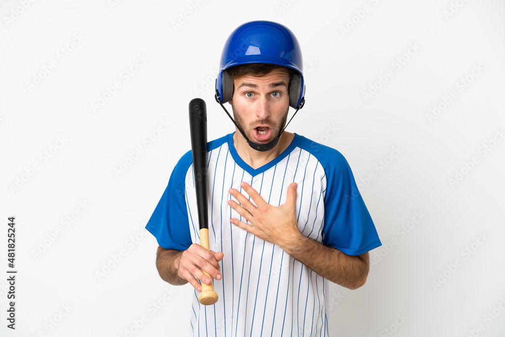 Young caucasian man playing baseball isolated on white background surprised and shocked while looking right
