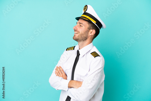 Airplane caucasian pilot isolated on blue background happy and smiling © luismolinero