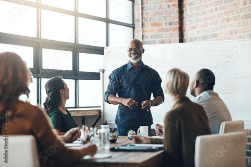 His presentation is motivating. Shot of a businessman giving a presentation to his colleagues in a boardroom.