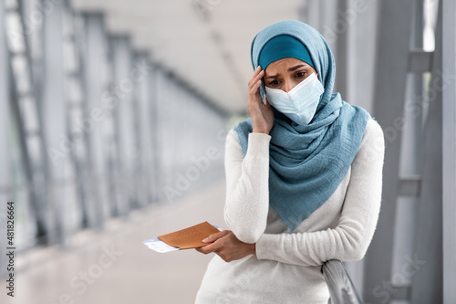 Cancelled Flight. Depressed Islamic Woman In Mask And Hijab Standing In Airport