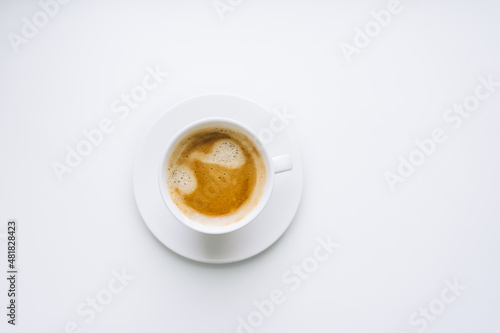 a white cup of coffee with a beautiful foam on a white background. 
