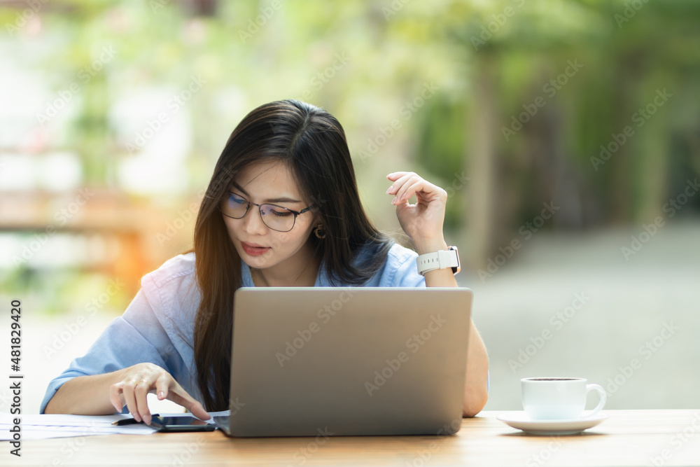 Asia Woman is working on the personal computer and smartphone at the internet work from home Asia Woman is working on the personal computer and smartphone at the internet work from home