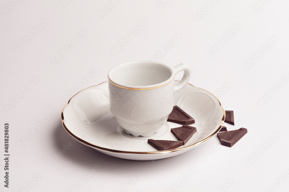 white cup with pieces of chocolate on white background