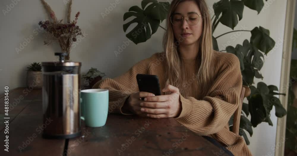 Girl textes on her smartphone while having her coffee Girl textes on her smartphone while having her coffee