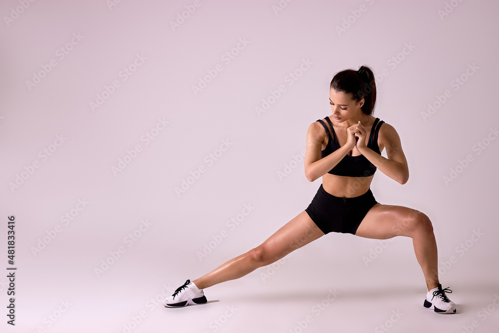 Young Fitness woman doing lunges exercises for leg muscle workout training, isolated in studio. Active athlete woman doing one leg step lunge exercise for butt. sport and fitness concept