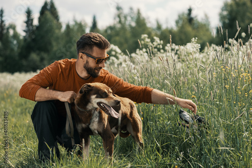 Photography Caucasian man and two dogs in tall grass in rural.