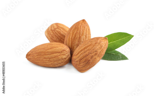 Organic almond nuts and green leaves on white background. Healthy snack