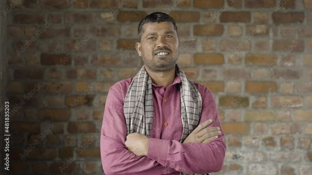 Smiling confident construction worker turns by looking camera at workplace - concept of manual labor and happiness Smiling confident construction worker turns by looking camera at workplace - concept of manual labor and happiness