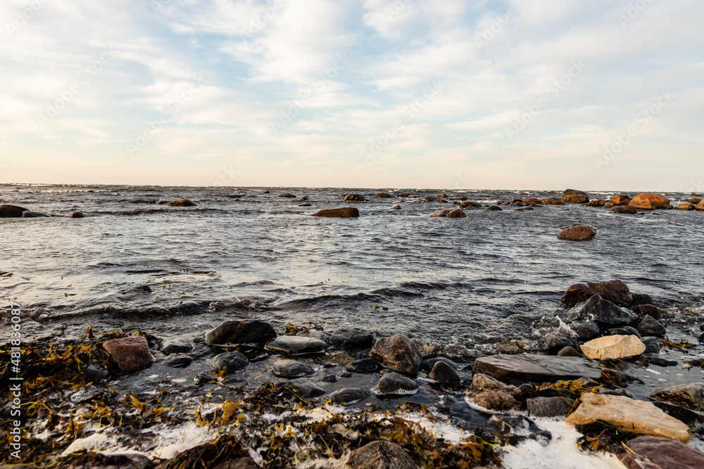 Rocky sea coast at dusk. Calm waves are reaching to coast during sunset. Coastal rocks and motion of ripples at sundown at Tahkuna, Hiiumaa, Estonia Rocky sea coast at dusk. Calm waves are reaching to coast during sunset. Coastal rocks and motion of ripples at sundown at Tahkuna, Hiiumaa, Estonia