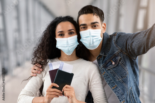 Travel Selfie. Young Arab Couple In Medical Masks Taking Photo In Airport