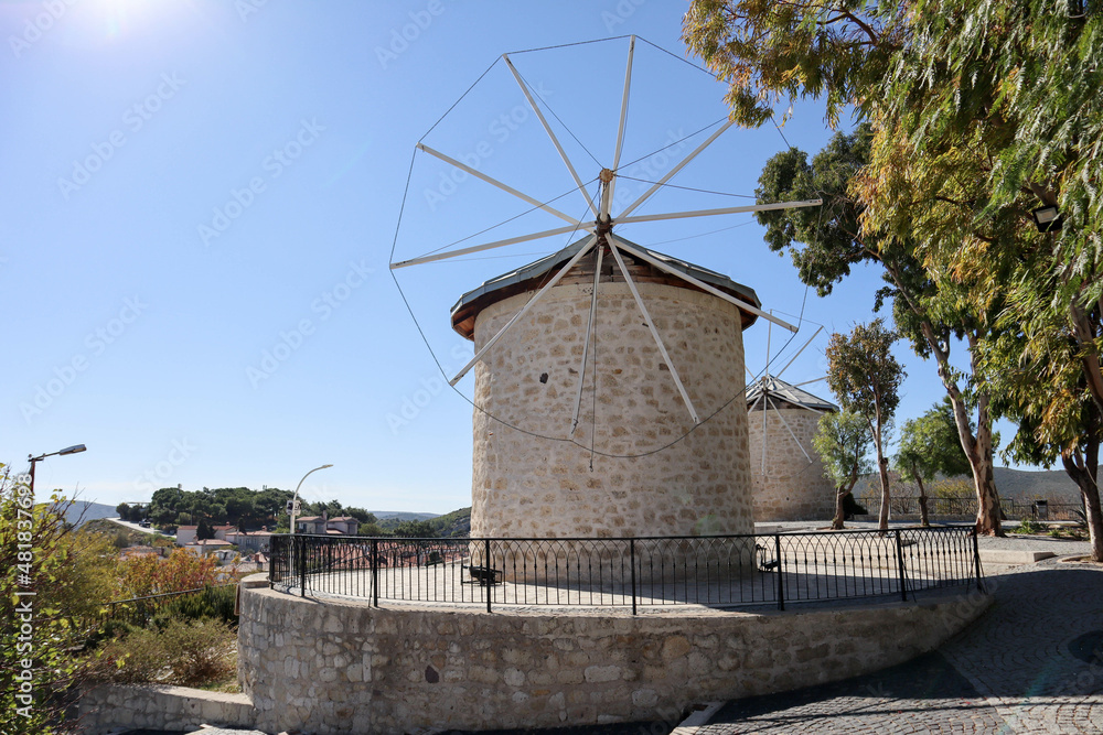 traditional windmill in Alacati, Turkey in sunny autumn day with blue sky on background