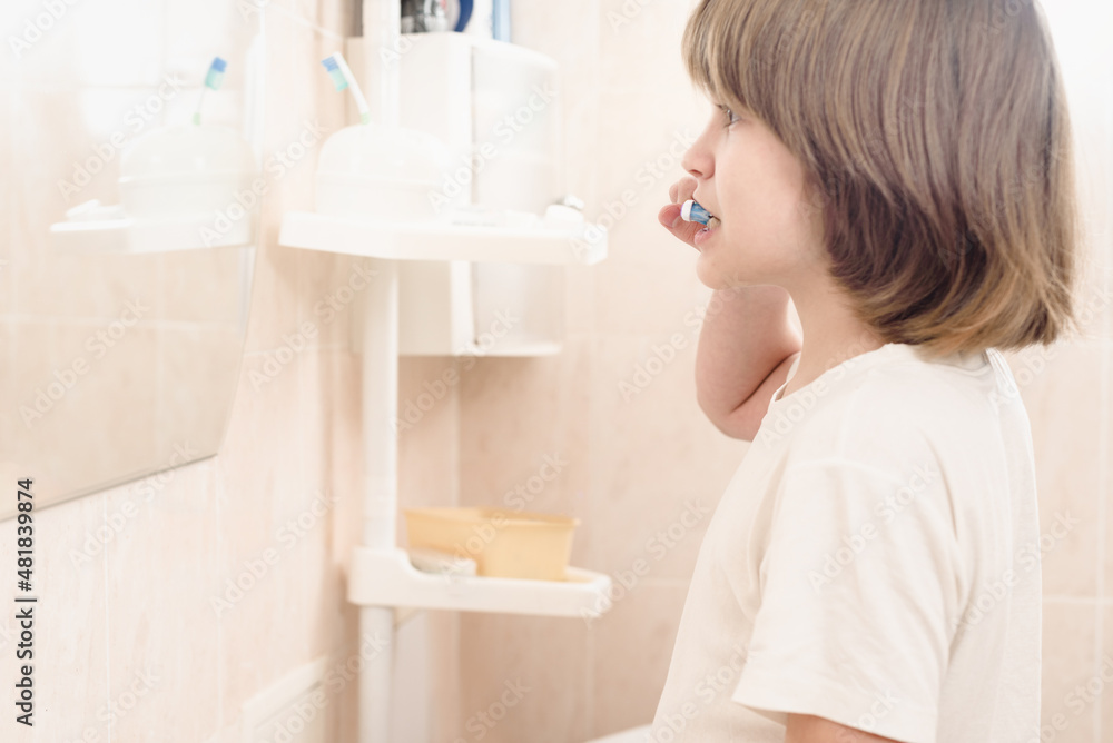 Young teenager boy with long blond hair brushing his teeth Young teenager boy with long blond hair brushing his teeth