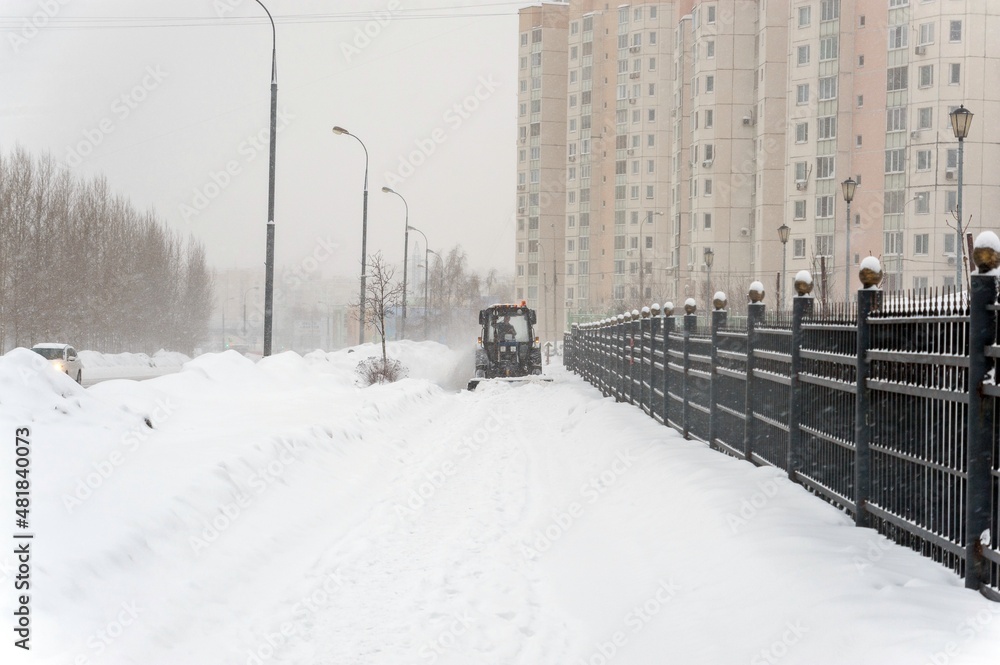Tractor clears snow from the sidewalk Tractor clears snow from the sidewalk