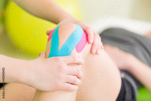 Bilde på lerret Taping des Knies während einer Physiotherapie Reha
