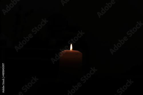Candle surrounded by total darkness