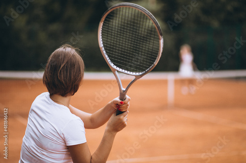 two women playing tennis at the court
