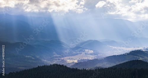 video of accelerated shooting from drone copter from a bird's eye view, time laps, clouds and rays of sunset quickly fly over the mountain peaks and valleys. Carpathians, Ukraine.