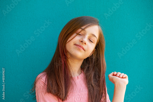 Girl in a pink dress on a turquoise background.