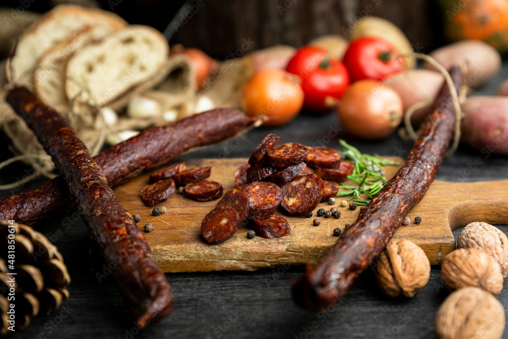 Smoked, aged sausages with fresh vegetables and food ingrediets Smoked, aged sausages with fresh vegetables and food ingrediets