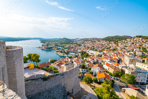Coastal view of Sibenik old city, Croatia. Cathedral of St James, adriatic sea with island in background. Summer weather, aerial view of city roofs. UNESCO heritage. photo