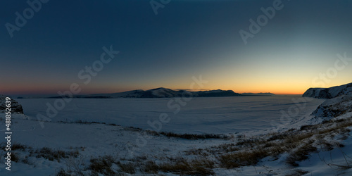 Sunset, view from the bank of the frozen river.