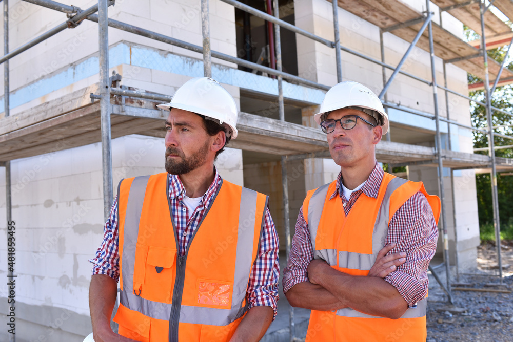 teamwork on the construction site - site manager and architect on site during the construction of a house teamwork on the construction site - site manager and architect on site during the construction of a house