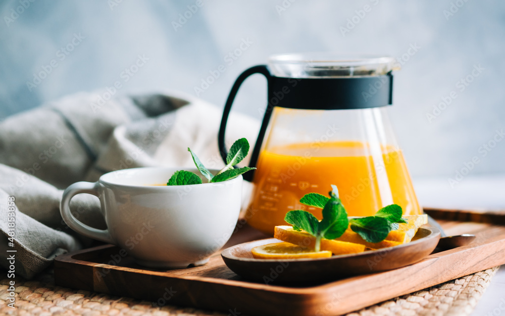 Brewed sea buckthorn tea in a teapot with orange in glass cups with fresh orange, mint and honey. Brewed sea buckthorn tea in a teapot with orange in glass cups with fresh orange, mint and honey.