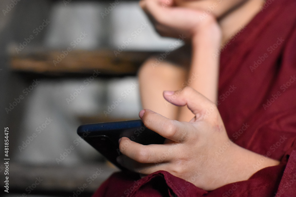 Asian little monk watching mobile smart phone. Concept of screen time. Asian little monk watching mobile smart phone. Concept of screen time.
