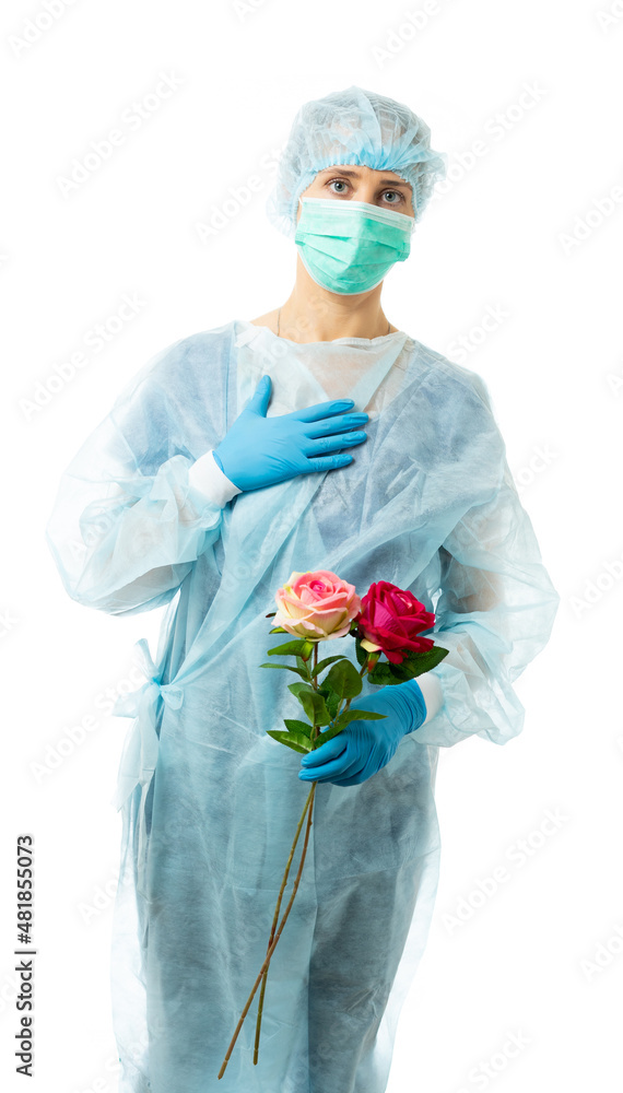 Laboratory Assistant, Doctor. A medic in a disposable medical gown, mask, glasses, hat, gloves holds two flowers as a sign of grief for the dead, dead. isolated Laboratory Assistant, Doctor. A medic in a disposable medical gown, mask, glasses, hat, gloves holds two flowers as a sign of grief for the dead, dead. isolated