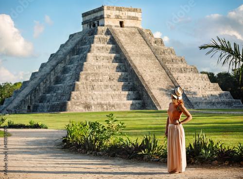  Girl tourist in a hat stands near the pyramid  in Chichen Itza.  Yucatan, Mexico photo