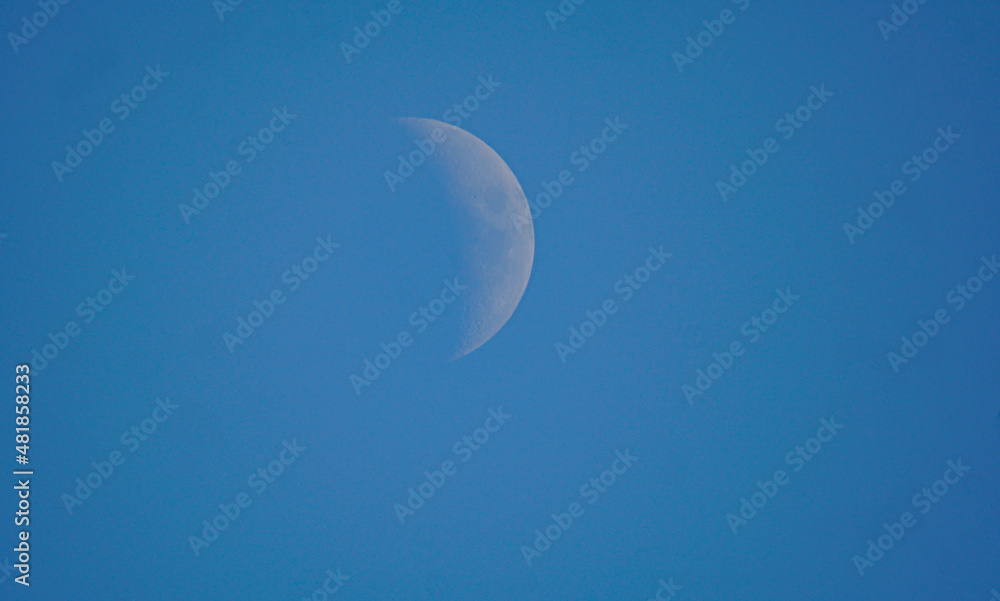 Half full moon and blue sky