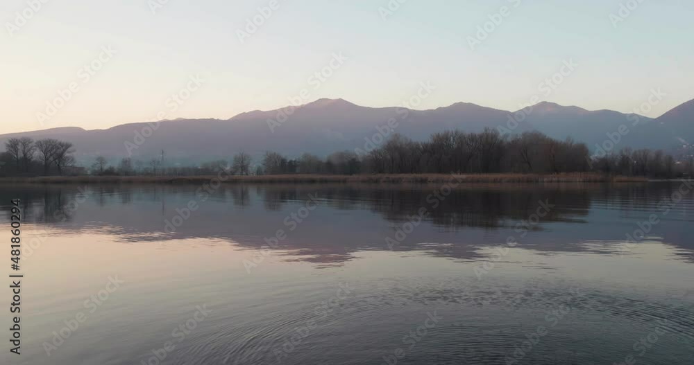Empty naturalistic landscape of a lake in winter. Camera goes backwards revealing a tree trunk on the shore. Empty naturalistic landscape of a lake in winter. Camera goes backwards revealing a tree trunk on the shore.