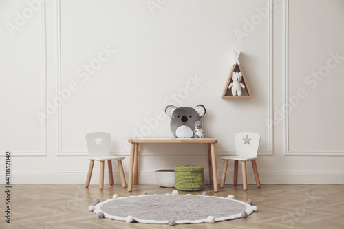 Cute child room interior with furniture, toys and wigwam shaped shelf on white wall
