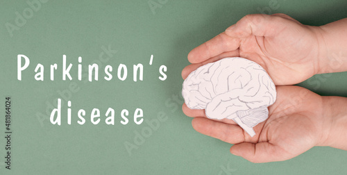 Parkinson s disease is standing on a paper  hands holding brain  dementia diagnosis  Alzheimer s illness