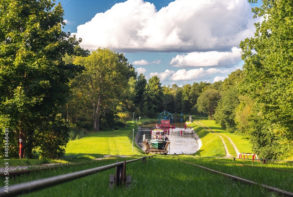Green nature of the Elbląg Canal (Kanał Elbląski), famous landmark of Warmian-Masurian, Poland. Boat hauled on the link cradle up the inclined plane to overcome the difference in water levels.