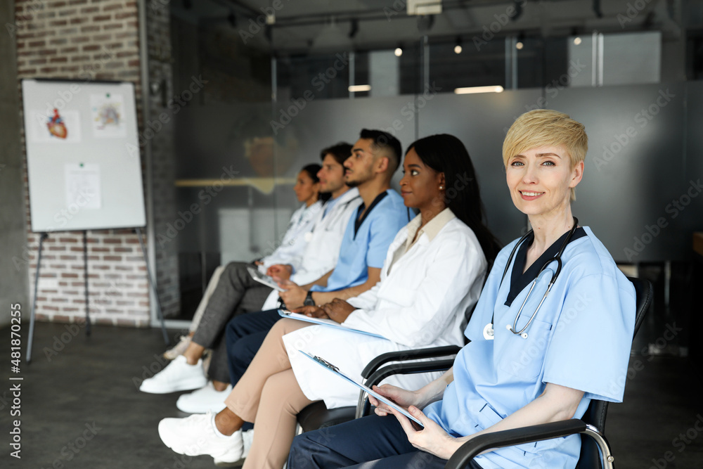 Obraz premium Blonde middle-aged woman doctor attending medical conference