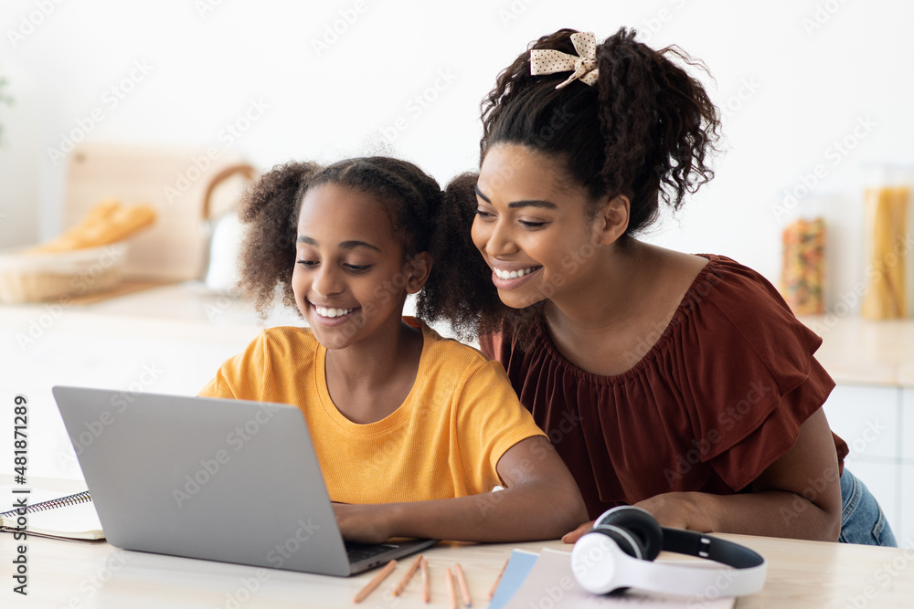 Cute black mother and kid using laptop together, closeup photo Cute black mother and kid using laptop together, closeup photo