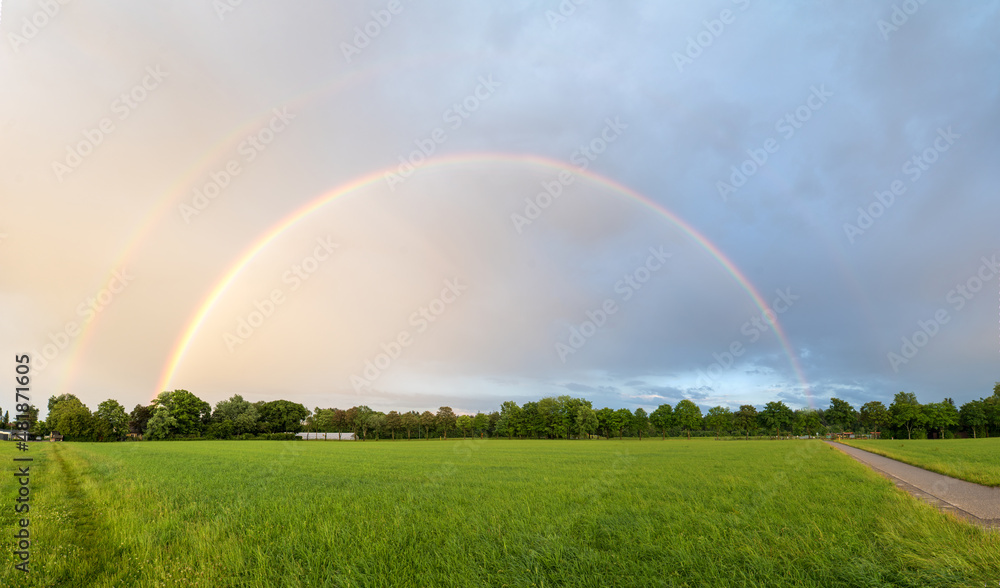 double rainbow over the fields, on the outskirts of hohenkirchen village, panorama landscape double rainbow over the fields, on the outskirts of hohenkirchen village, panorama landscape