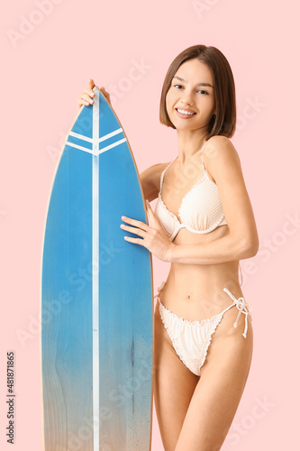 Beautiful young woman with surfboard on color background © Pixel-Shot