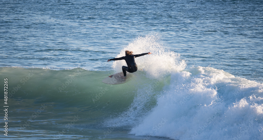 Young surfer riding perfect surf wave at the beach of Caños de Meca