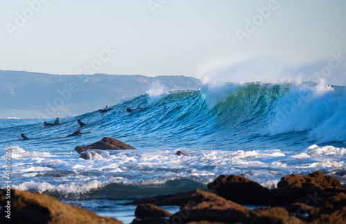 Surfers riding waves in Los Caños de Meca, South Spain