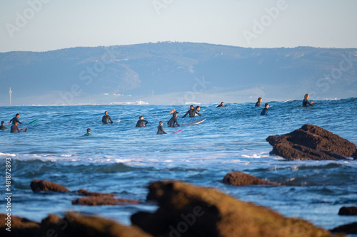 Surfers waiting for waves in Los Caños de Meca, South Spain with Morocco in the background