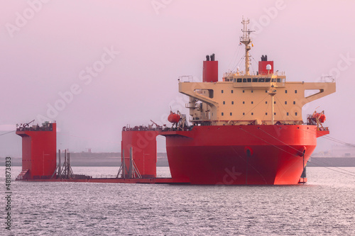 Rotes Halbtaucherschiff wartet im Hafen auf seine Ladung