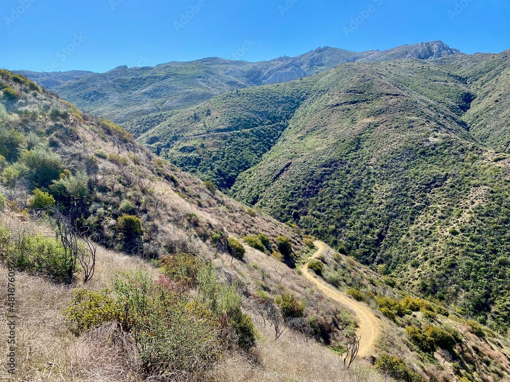 View across Santa Monica Mountains at Point Mugu State Park, California, on a clear sunny day with winding trail visible